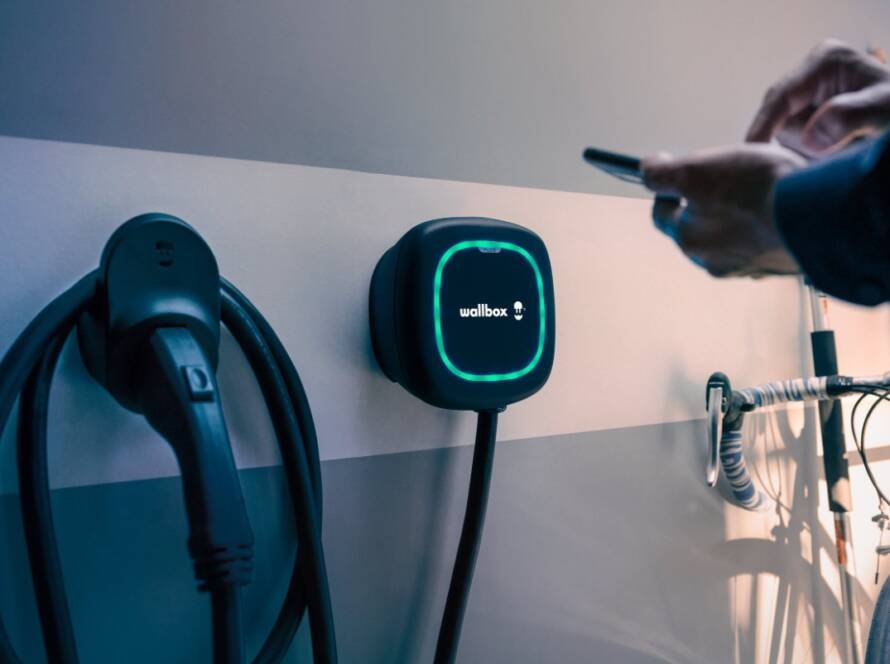 Tecnología clave para cargar autos eléctricos mediante sistema Wallbox instalado en estación de carga moderna.