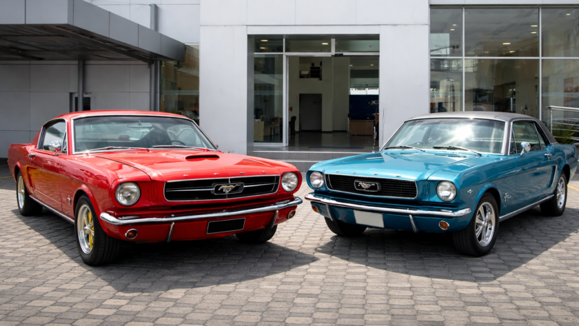 Exhibición de vehículos Ford Mustang clásicos y modernos en evento automotriz en Quito
