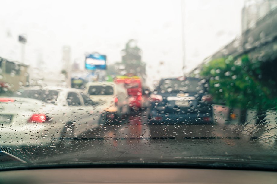 Vehículos circulando bajo lluvia intensa en vía urbana de Ecuador — siniestros viales en temporada invernal