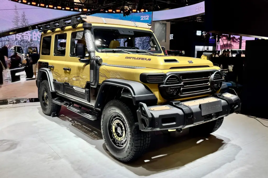 Vista frontal y lateral del 212 T01 edición Battlefield, vehículo 4×4 de origen militar en color beige arena, exhibido en el Salón de Beijing