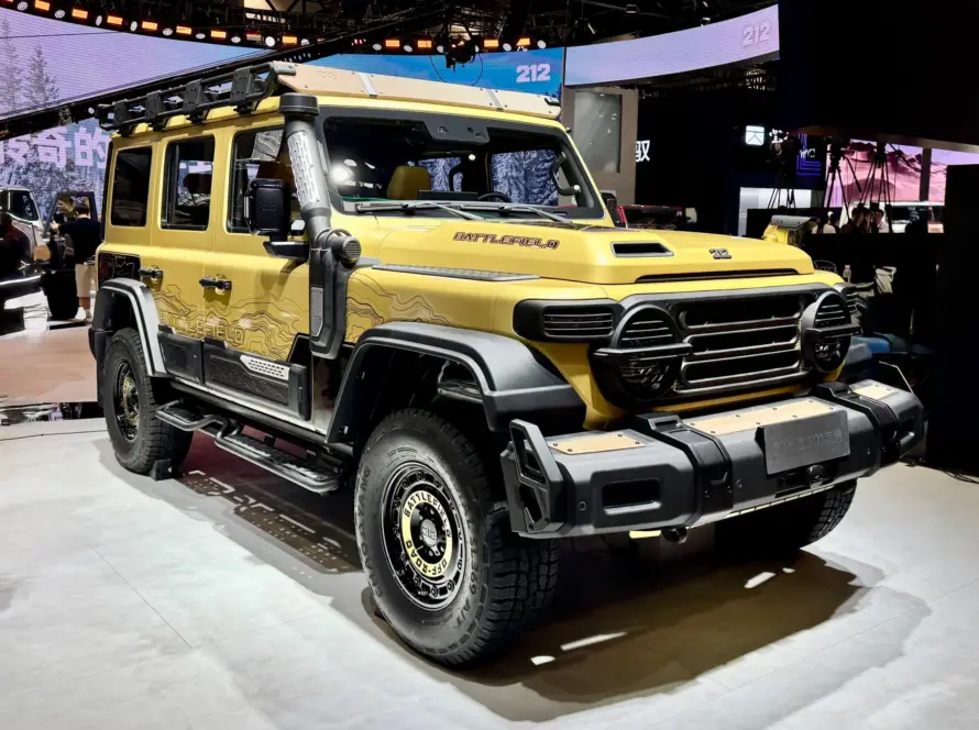 Vista frontal y lateral del 212 T01 edición Battlefield, vehículo 4×4 de origen militar en color beige arena, exhibido en el Salón de Beijing