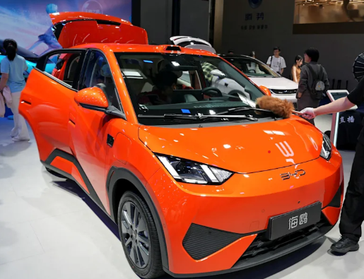 Vehículo eléctrico BYD Seagull 2026 exhibido en el Salón del Automóvil de Pekín, con personal limpiando su superficie