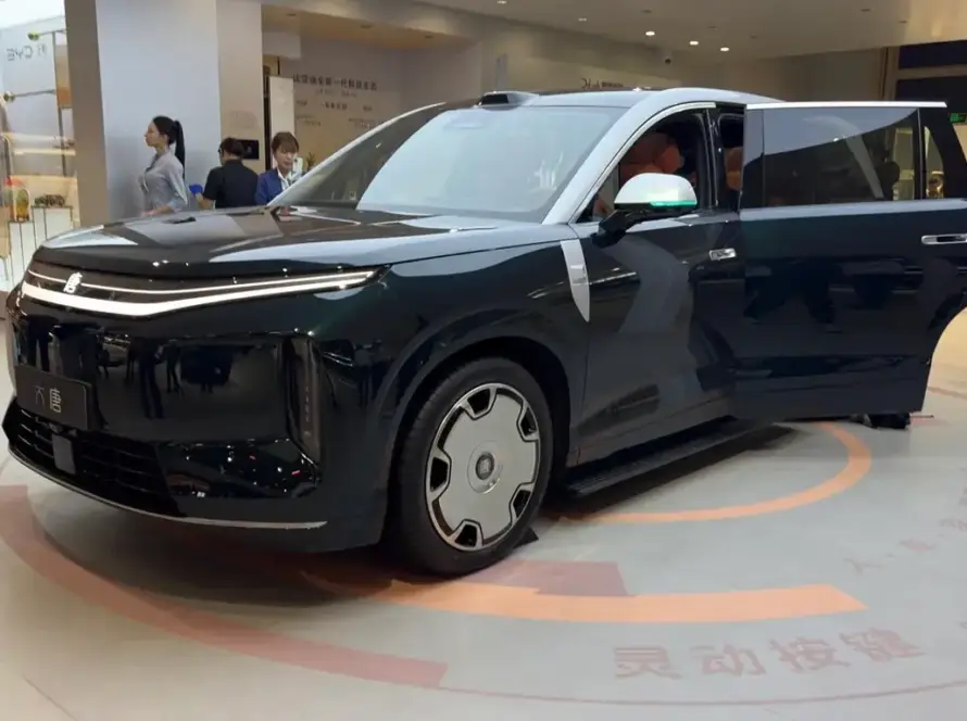 Una fila de SUV chinos grandes y modernos, con diseños aerodinámicos y faros LED brillantes, estacionados en un salón de exhibición con un ambiente futurista. Se aprecia el tamaño imponente y la sofisticación de los vehículos.
