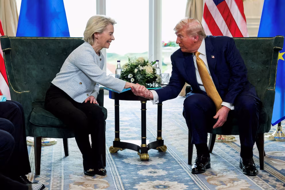 Donald Trump hablando en un podio, con un coche de marca alemana (por ejemplo, BMW o Mercedes-Benz) difuminado en el fondo, simbolizando el impacto del arancel del 25%