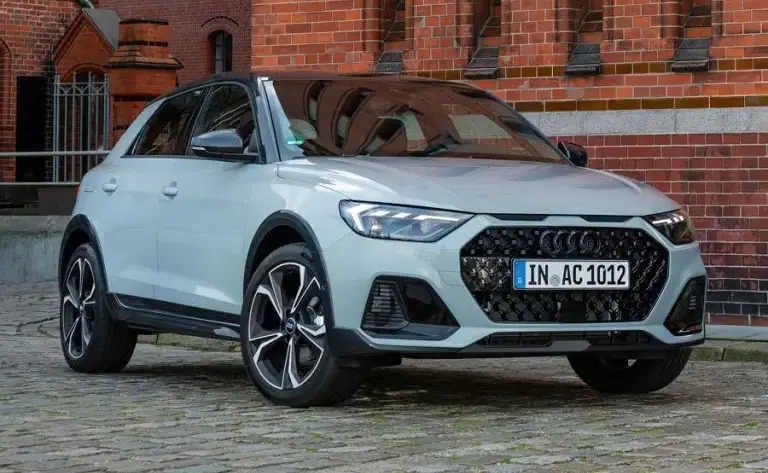 Imagen de un Audi A1 y un Audi Q2 simbolizando el fin de su producción, con un fondo futurista que insinúa la electrificación.