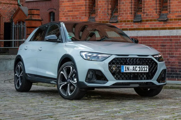 Imagen de un Audi A1 y un Audi Q2 simbolizando el fin de su producción, con un fondo futurista que insinúa la electrificación.
