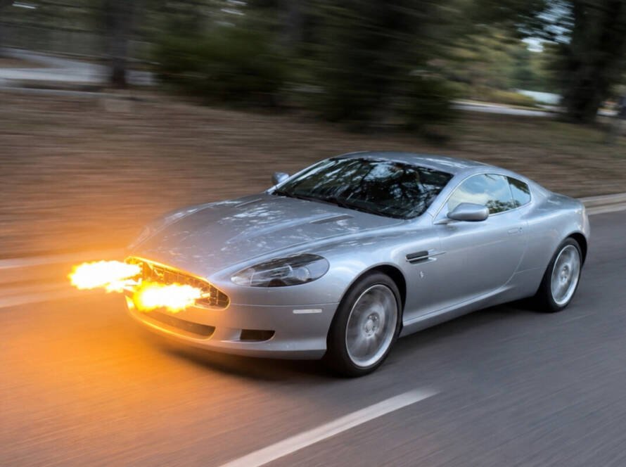 Aston Martin DB9 modificado, este auto tiene lanzallamas visibles saliendo de su parrilla frontal, diseño inspirado en James Bond