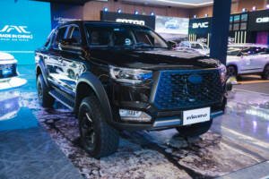El nuevo vehículo SUV JAC JS6 Híbrido Enchufable exhibido con luces brillantes en el stand de la feria automotriz Motor 360 en Cuenca.