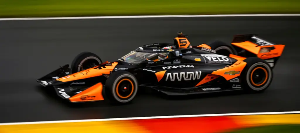 Monoplaza de la IndyCar en pista, con referencia al sistema híbrido y la reducción de potencia aplicada