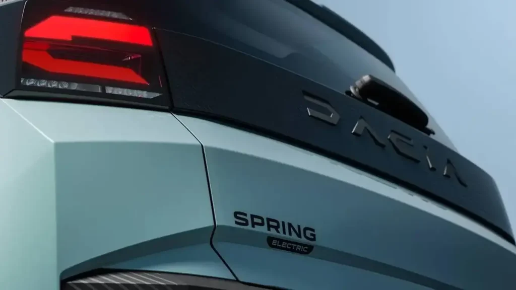 Vista frontal de la segunda generación del nuevo Dacia Spring estacionado sobre una vía urbana.