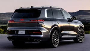 Audi Q9 2027 de color oscuro mostrando su diseño frontal, gran parrilla y carrocería de SUV de lujo.