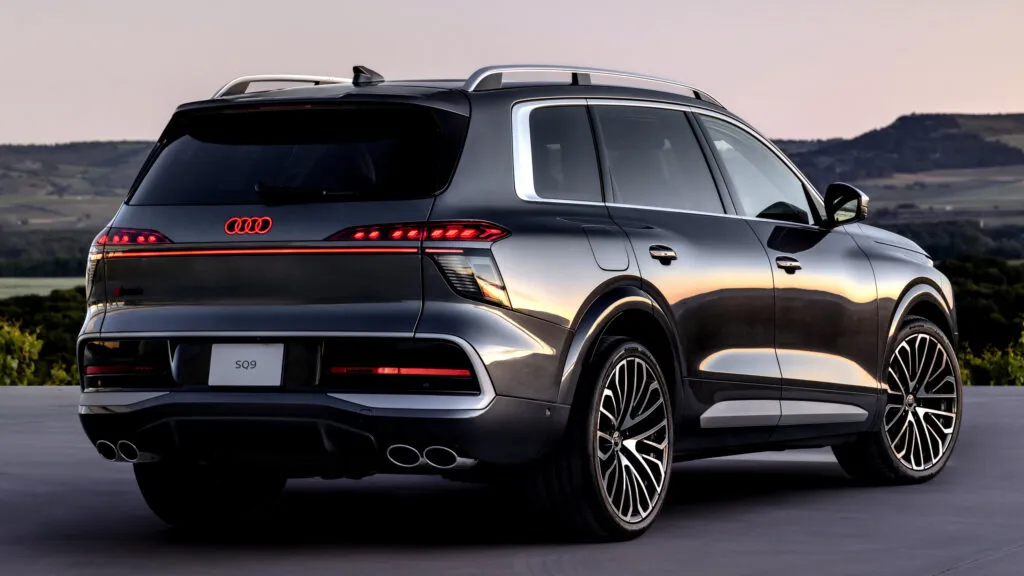 Audi Q9 2027 de color oscuro mostrando su diseño frontal, gran parrilla y carrocería de SUV de lujo.