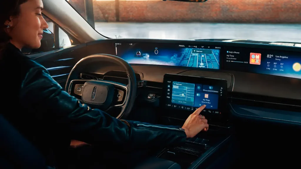 Pantalla del sistema informático mostrando la audioguía Autio en Ford y Lincoln durante un viaje.