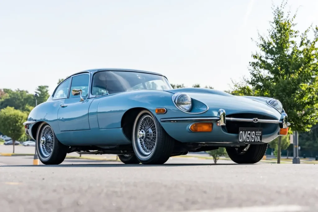 Deportivo clasico azul claro en un evento donde Bring a Trailer subasta un Jaguar E-Type Series II