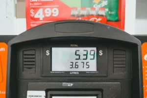 Camión de transporte de mercancías repostando combustible en una estación de servicio con el precio del diésel en alza.